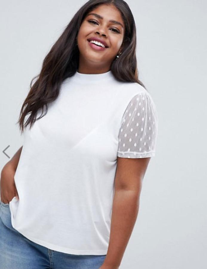 Camiseta con cuello subido con detalle en la mangas de tela de malla malla y con lunares, 19,99 euros.