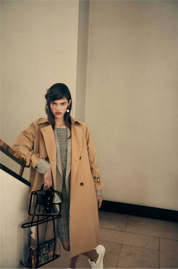 Las capas y el 'mix&match' de estampados de cuadros son una constante en la propuesta 'working girl' de Zara, y este look es pura inspiración. ¿Qué nos queremos comprar? El vestido de cuadros (39.95 euros) y el trench (59.95 euros)