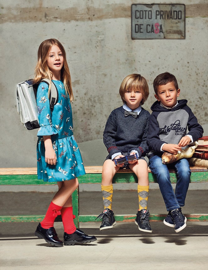 Claudia lleva vestido de El Corte Inglés, mochila de Bon Ton, calcetines de Cóndor y zapatos de Pablosky. Bruno, camisa de Mayoral, calcetines de Cóndor y deportivas de Pablosky. Mario viste sudadera, camisa y zapatos de Mayoral. El vaquero es de Primark.