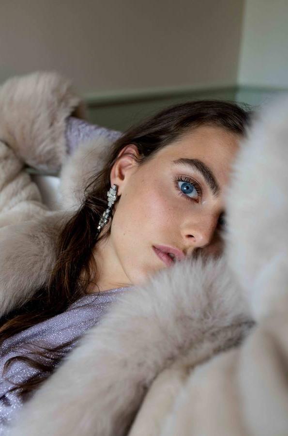 En las prendas exteriores, el pelo es el rey. En este caso, contrasta con los brillos de las prendas.