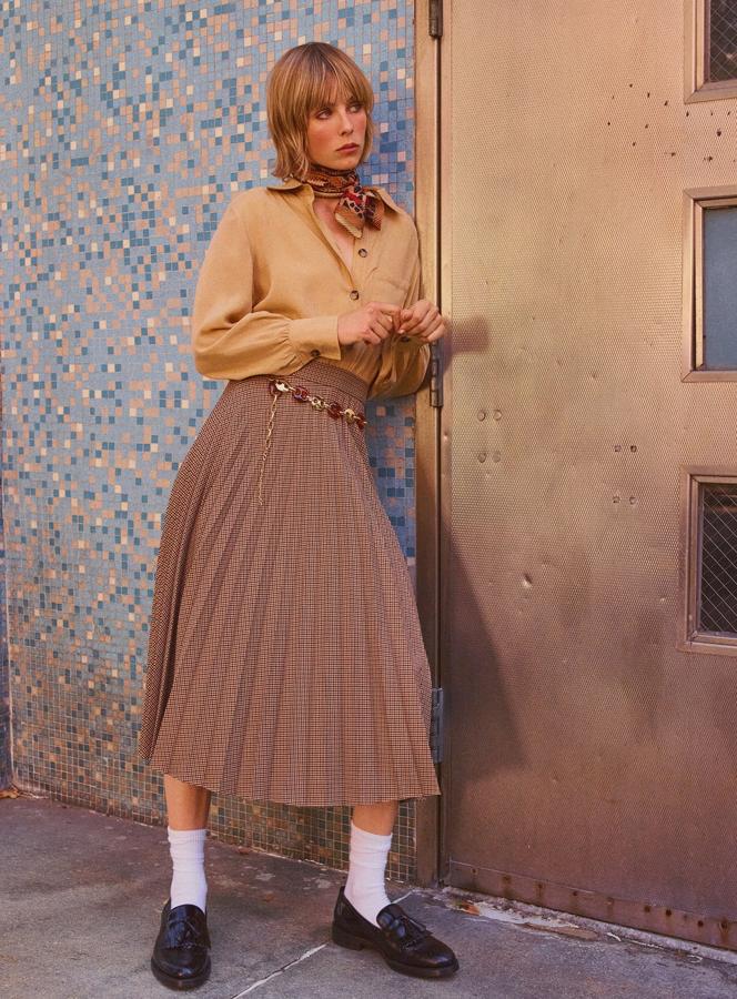 Este conjunto es espíritu 'setentero' puro, tanto por las prendas, como por cómo se combinan. La falda midi tableada con estampado 'pata de gallo' es la protagonista del look (39.95 euros), y el detalle de los calcetines (7.95) con los mocasines (69.95 euros), el pañuelo (9.95 euros) y el cinturón de cadenas (17.95 euros) marcan la diferencia.