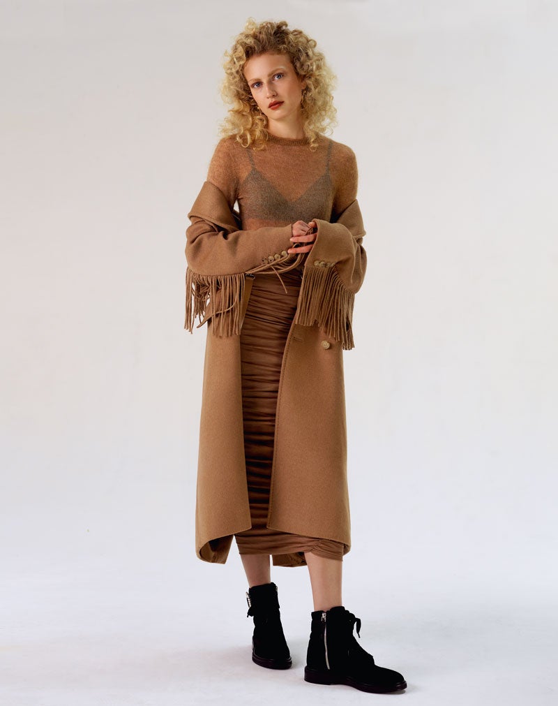 Abrigo con flecos, jersey de punto y falda drapeada, todo de Max Mara. El sujetador es de Eres. Las botas de terciopelo son de Roger Vivier.