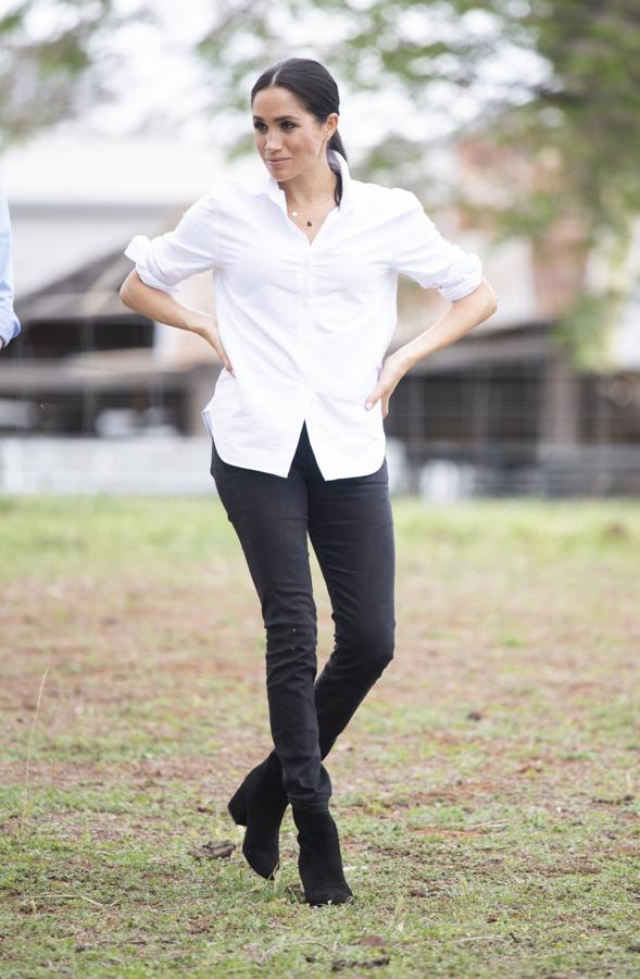 Para visitar la ciudad de Dubbo, Meghan Markle apostó por un look mucho más 'sporty chic' en el que combinó pantalón negro de la firma australia Outland Denim con una camisa blanca de inspiración masculina de Maison Kitsuné y botines de tacón ancho de J. Crew.