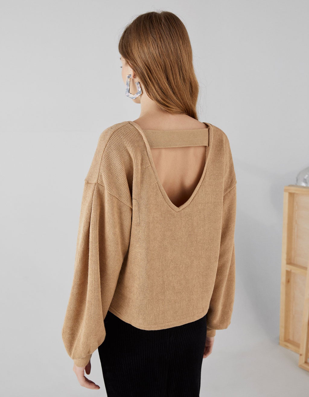 Una opción diferente es trasladar la abertura a la espalda. Con este jersey de Bershka serás la más original. (15,99 euros).