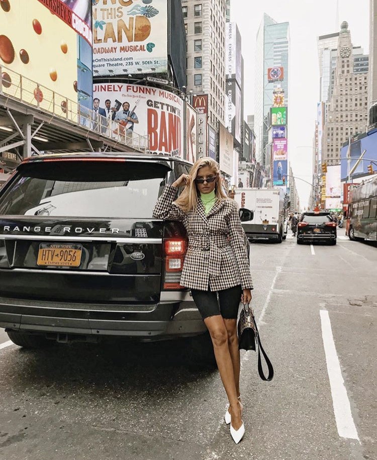 Las mallas ciclistas han dado la vuelta al mundo. Es una de las tendencias de este otoño y ya si lo combinas con una blazer de cuadros, tendrás el look perfecto. Teresa Andrés le añade glamour con unos zapatos de tacón blancos y un jersey en tono flúor.