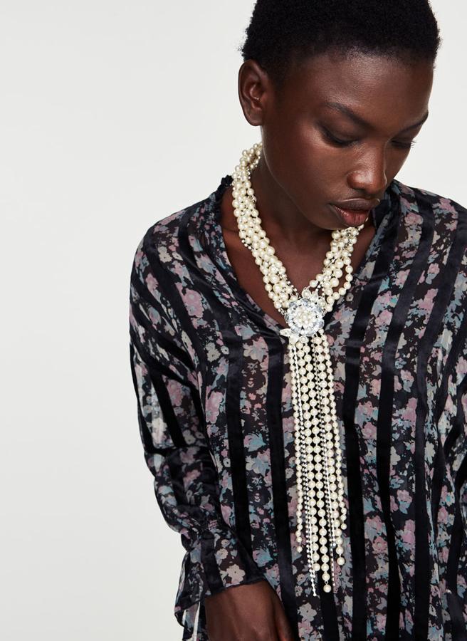 Largo y con una gargantilla de cristal engarzado y perlas en diferentes tonalidades y tamaños. Cierra mediante imán con detalle circular en forma de flor con pedrería (99 euros).