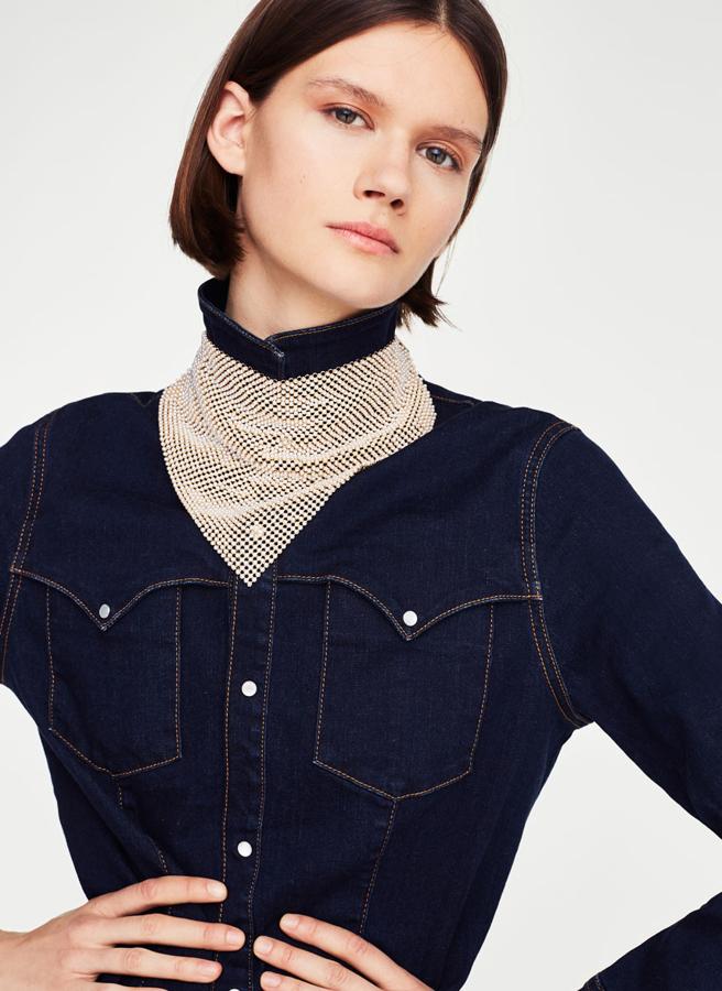 Una malla metálica en tono dorado con detalle de perlas y cordones con pompones con flecos como lazada (89 euros).