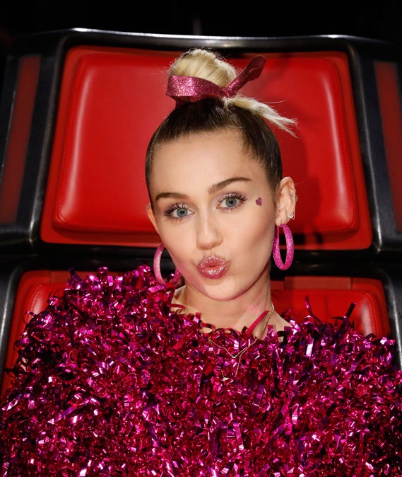 Uno de los looks más teenager de Miley Cyrus es este de inspiración bailarina que consigue gracias al moño perfecto que combina con un lazo y al maquillaje glitter tanto en las sombras de ojos como en los labios.
