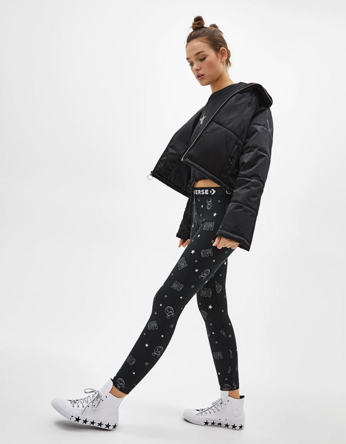 Con efecto satén, cuello subido y cierre delantero con una cremallera metálica que termina en una anilla (130 euros).