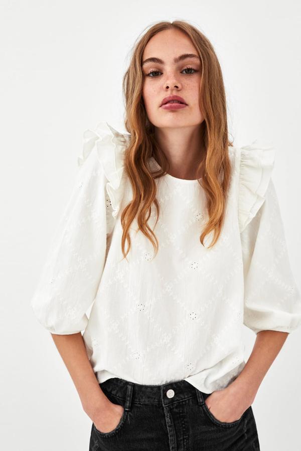 Cuerpo de cuello redondo y manga abullonada por debajo del codo, con detalle de volante doble en hombros, bordados a tono y línea evasé (Zara, 25,95 euros).