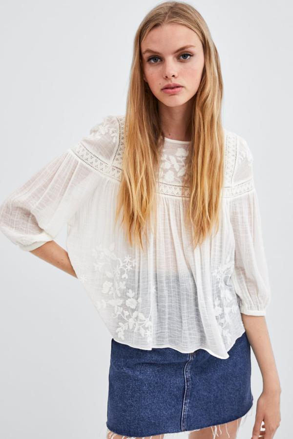 Maravillosa blusa bordada con flores y con un detalle de encaje y calado (Zara, 25,95 euros).