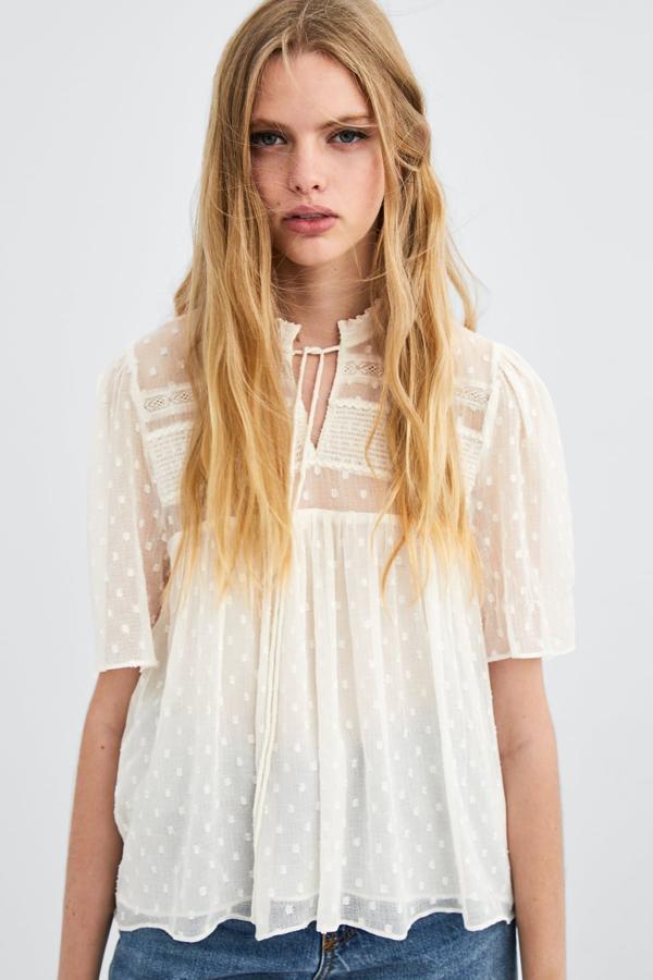 Cuerpo de cuello redondo y escote pico, con detalle de lazo en el mismo tejido y línea evasé amplia desde el pecho (Zara, 22,95 euros).