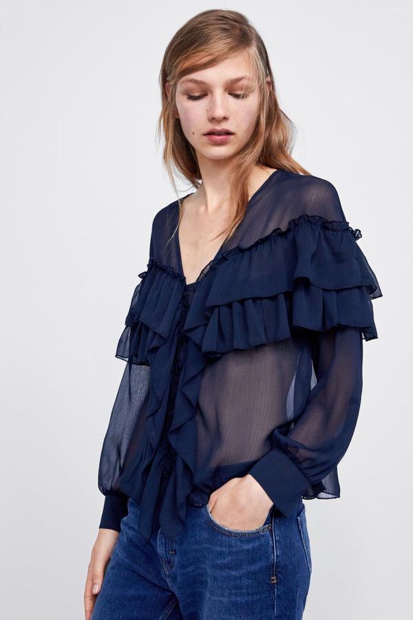 Blusa fluida semitransparente en azul marino, con escote pico y manga larga acabada en puño. (Zara, 25,95 euros).