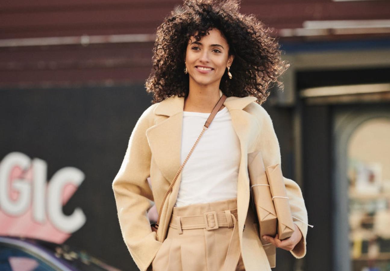 nos encanta el estilismo entero: una sencilla camiseta blanca (4,99 euros), el pantalón "paper bag", tobillero y con pizas, esta vez en color cremoso (49,99 euros), y el fantástico abrigo en mezcla de lana suave, con mangas ranglán y cierre abotonado (99 euros).