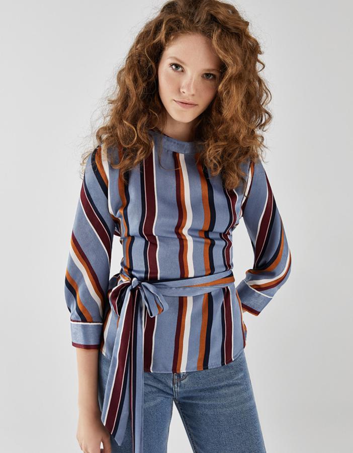 Camisa de satén con estampado d erayas verticales y detalle de lazada en la cintura, 12,99 euros.