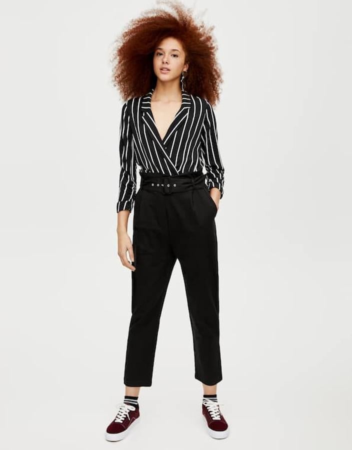 Un look perfecto para acudir a la oficina: pantalones negros fluidos con cintura "paper bag" (19,99 euros) y camisa negra con rayas blancas, con manga francesa y cuello solapa (19,99 euros).