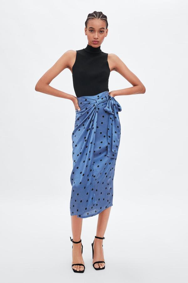 Falda tipo pareo con estampado de lunares en color negro y con cinturón de lazada, 25,95 euros.