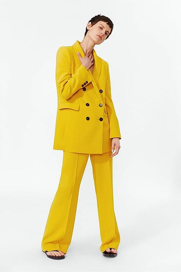 Blazer cruzada con botones (79,95 euros) y pantalón flare amarillo (39,95 euros).