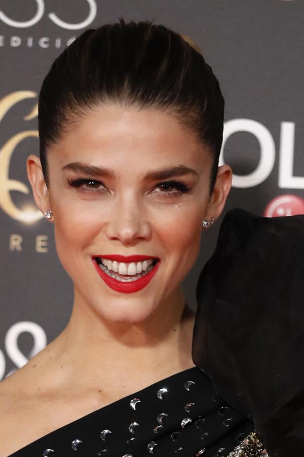 Las pestañas se curvan en la zona exterior de sus ojos para crear un efecto todavía más almendrado. Y los labios se dibujan en rojo festivo que le va como anillo al dedo.