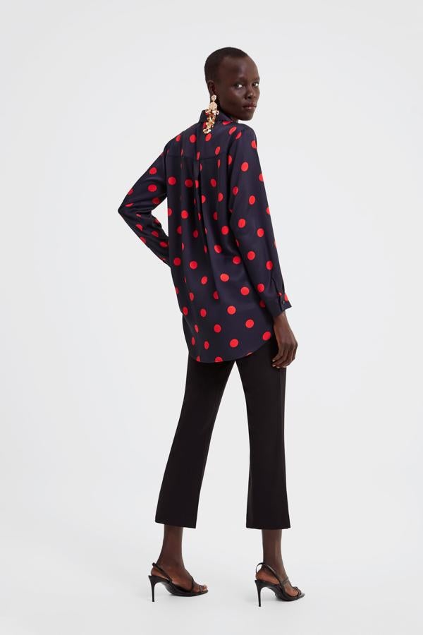 Esta blusa oversize de lunares rojos sobre fondo azul marino cuesta 19.95 euros en Zara.