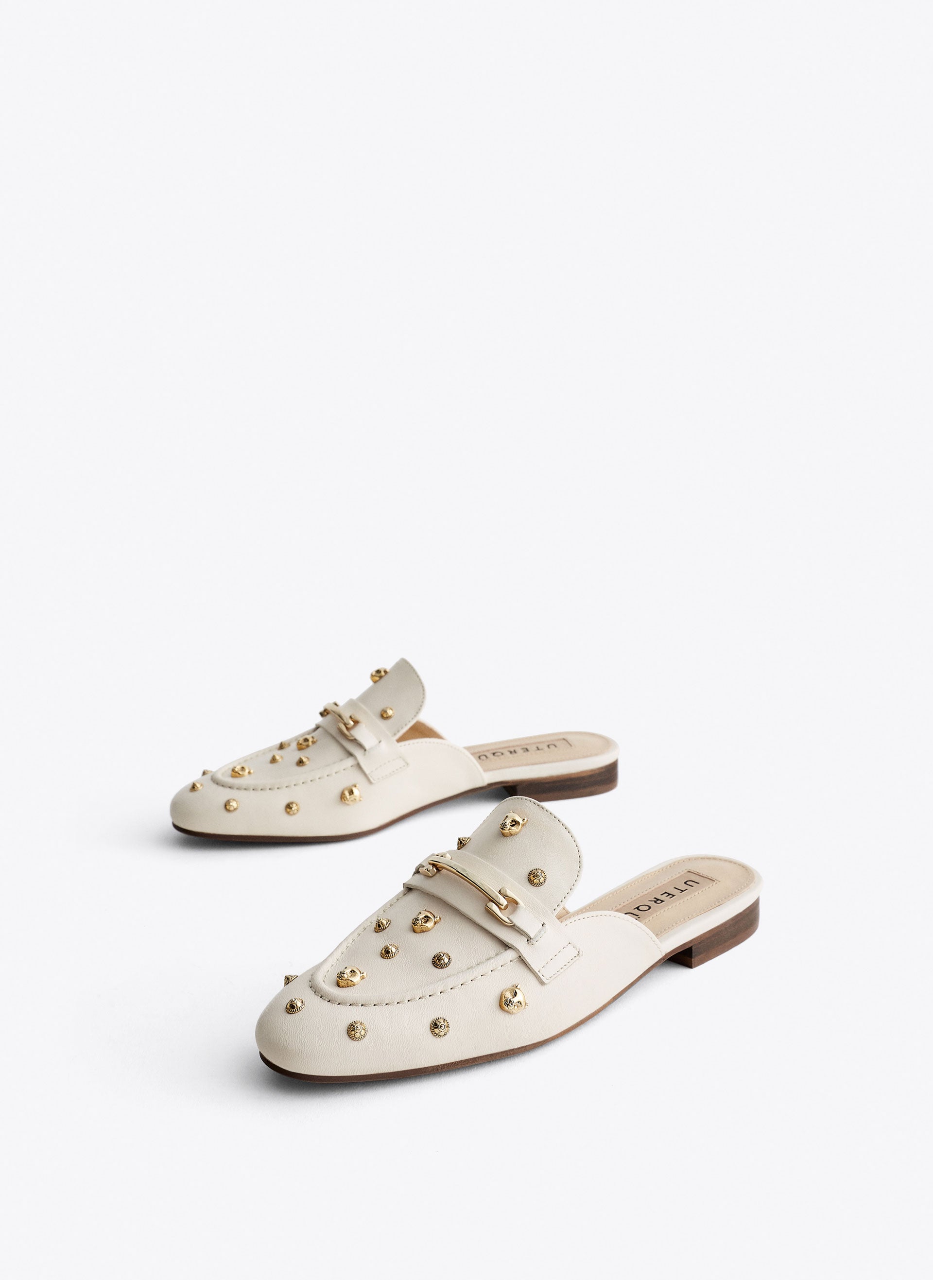 Clásicos, pero con un maravilloso toque irreverente. Estos mules tipo mocasión con detalles dorados de Uterqüe son, además, 'made in Spain'. Precio: 99 euros.