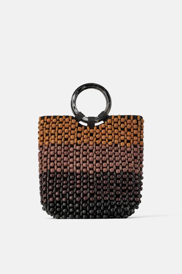 Bolso shopper en combinación de colores, con una estructura de bolitas en el cuerpo. Lleva las asas de mano circulares de metacrilato y el interior forrado y con un bolsillo (35,95 euros).