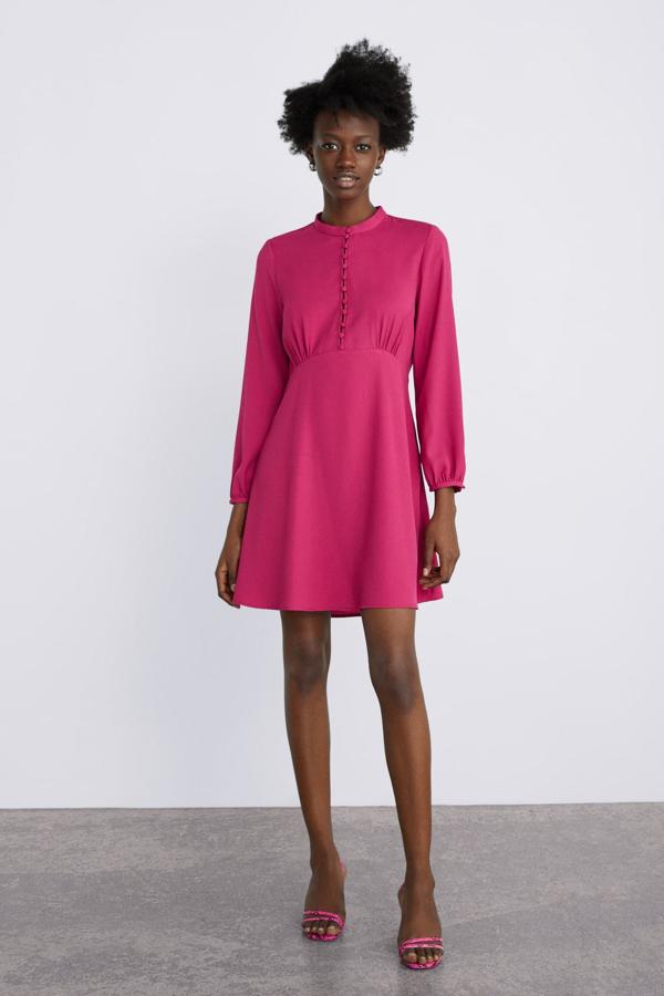 Vestido corto con cuello subido, manga larga, detalle de botonadura frontal y fruncido en la cintura, 29,95 euros.