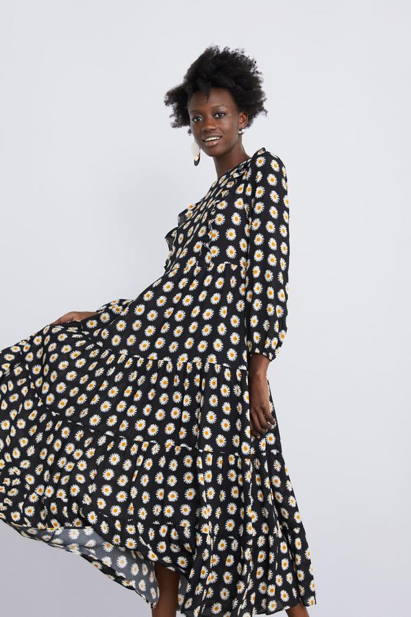 Maxi vestido con estampado de margaritas sobre fondo negro y volantes XXL en la falda. En Zara, 49.95 euros.