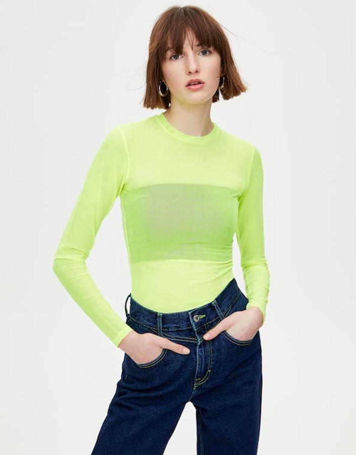 Camiseta de tul de manga larga con cuello redondo, semitransparente y verde flúor (9,99 euros) sobre top 'bandeau' negro (3,99 euros).