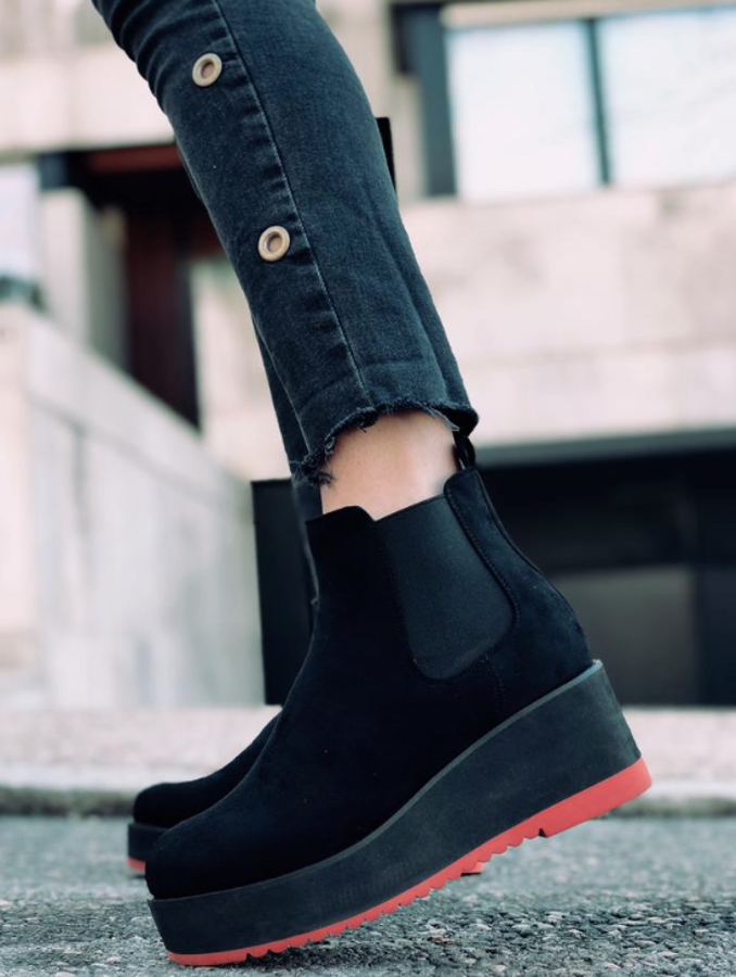 Botines de color negro con goma elástica alrededor del tobillo. En la suela, lleva una goma ultraligera con un detalle de línea roja en la parte inferior (72 euros). La altura de la plataforma es de 5 centímetros.