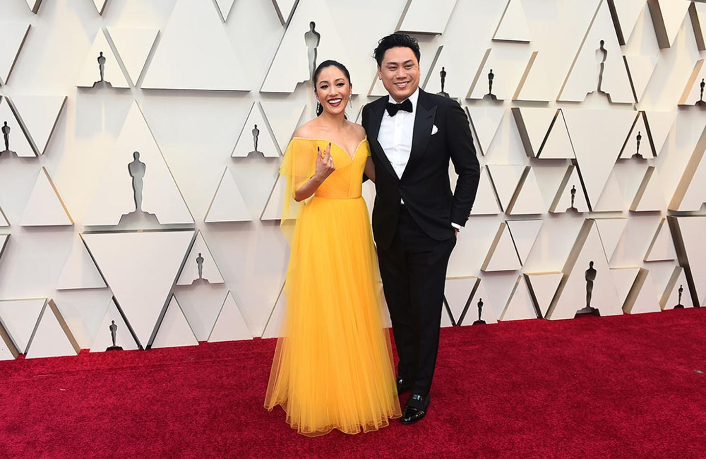 Constance Wu Jon y Jon M. Chu posan en la alfombra roja de los Premios Oscar 2019.