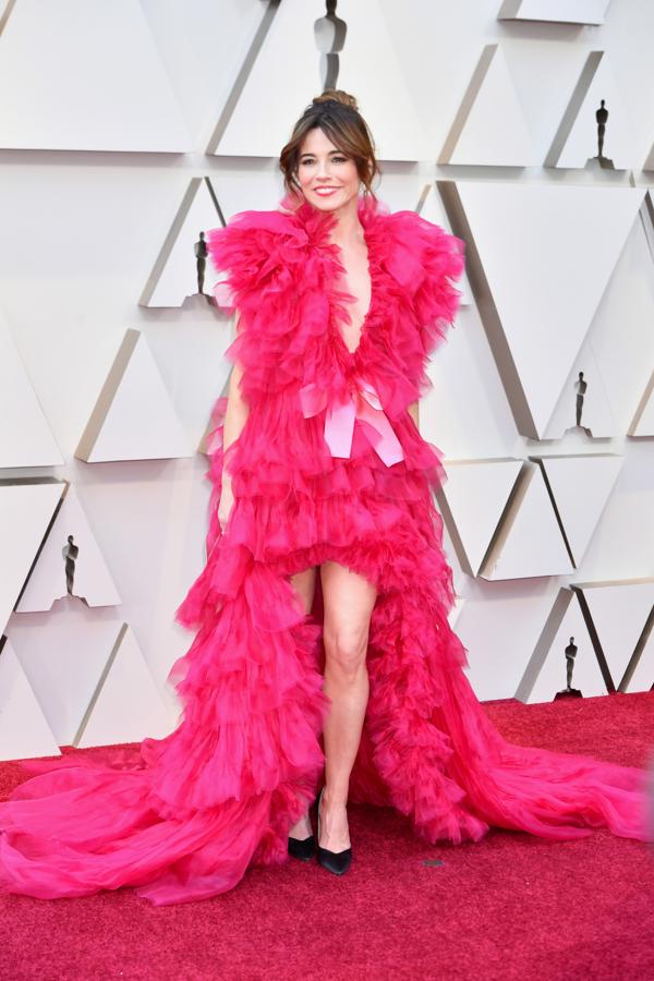 Linda Cardellini con un vestidazo nada discreto en tul fucsia con volantes y falda con abertura delantera en los Oscar 2019. Lo firma Schiaparelli.