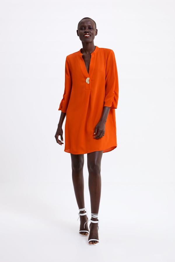 Vestido de estilo camisero, de tejido fluido con esciote en pico y detalle de botón, 29,95 euros.