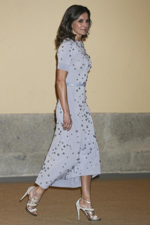 La Reina sabe cuáles son las siluetas que mejor le sientan, y la de este vestido es todo un acierto: de largo midi ligeramente asimétrico, cuello subido y muy entallado, le queda como un guante. Además, el color gris lavanda está de plena tendencia, y los detalles de estrellas joya bordadas le aportan una sofisticación máxima.