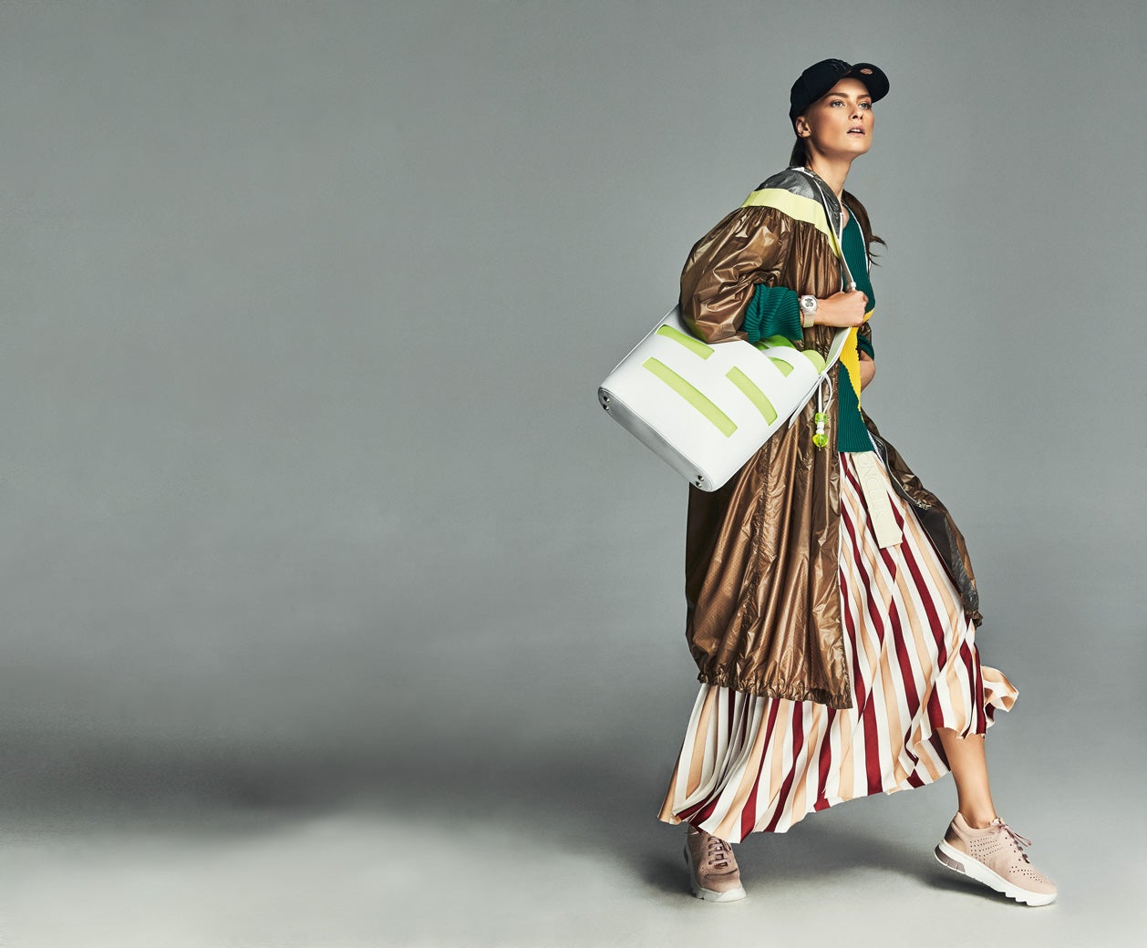 Jersey, falda y cortavientos deportivo, todo de Moncler. Reloj de Tous, gorra de New Era y zapatillas Stonefly. El bolso es de Hogan.