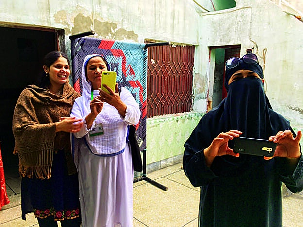 Una vecina de un barrio marginal de Lahore, junto a dos ladies health workers, que dan información y asistencia a las mujeres.