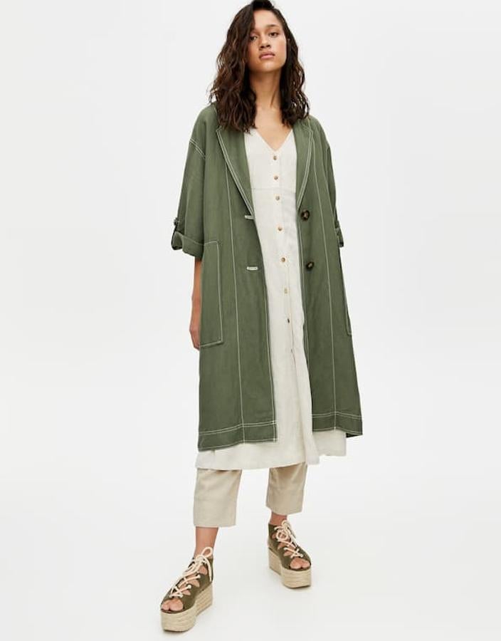 Abrigo de estilo rústico confeccionado en viscosa y lino con costuras en contraste, cuello de solapa, bolsillos y cierre de botones en contraste (Pull&Bear, 39,99 euros).