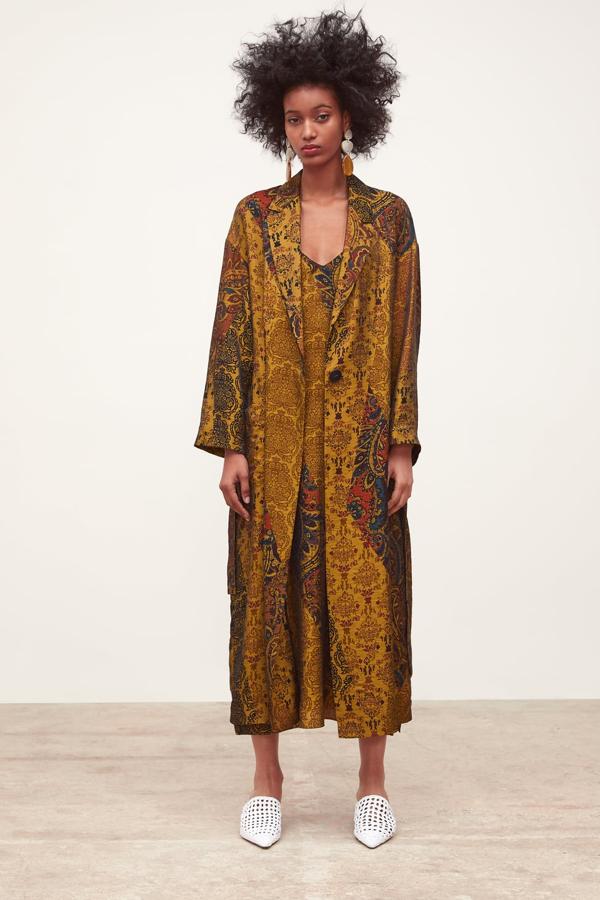 Ligerísimo abrigo, casi un batín, con cuello de solapa y manga larga amplia. Lleva bolsillos delanteros de plastrón y un cinturón del mismo tejido (Zara, 59,59 euros).