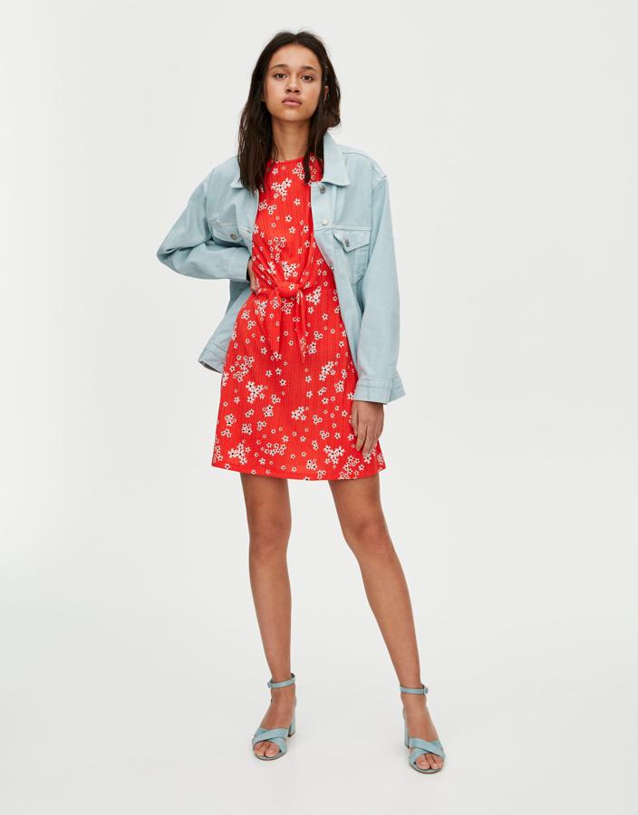 Mini vestido rojo con estampado de flores y detalle de nudo a la cintura, de Pull&Bear (17.99 euros).