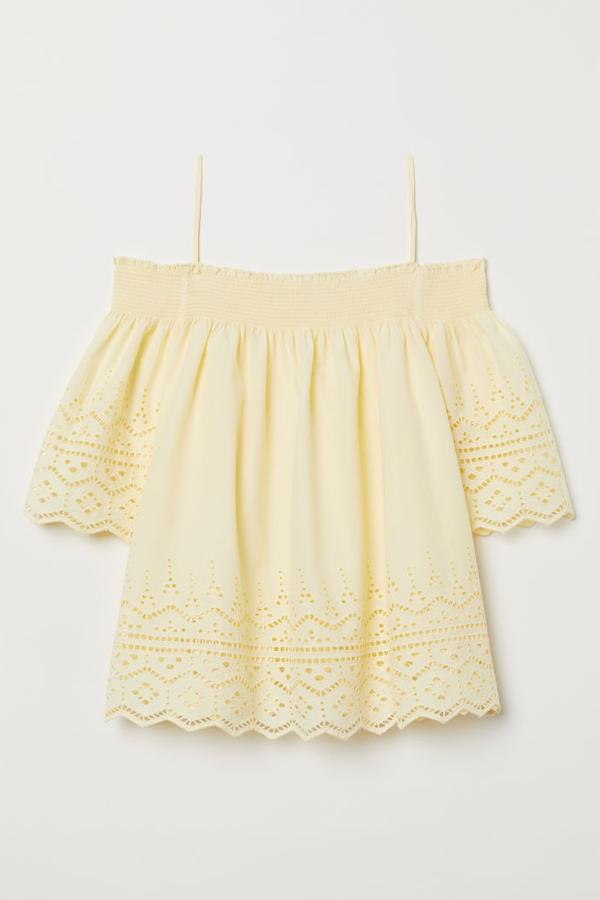 Blusa en tejido de algodón con bordado inglés, hombros con hombros 'cut-out', sección fruncida en la parte superior, tirantes finos y mangas amplias (19,99 euros).