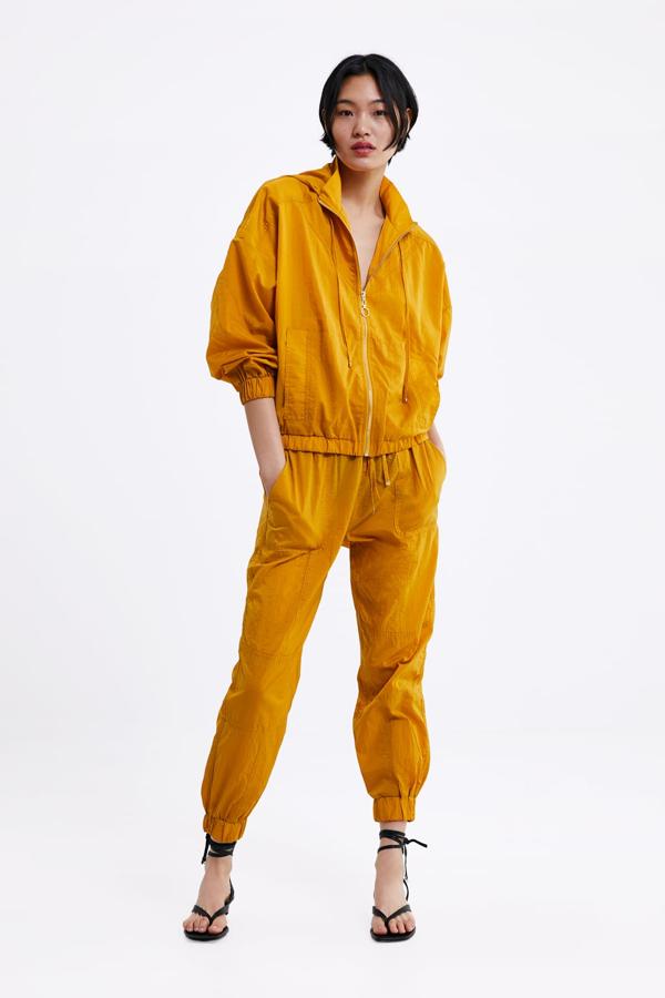 Chaqueta amplia con efecto arrugado y capucha ajustable en color mostaza (29,95 euros) combinada con pantalón jogger arrugado (19,95 euros).