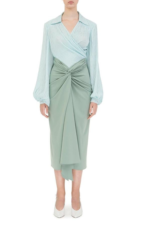 Rápidamente hemos descubierto que se trata de un diseño midi de la firma ucraniano-belga Flow The Label en un maravilloso verde aguamarina (uno de los colores de la temporada, como demostraba hoy la Reina Letizia) y que, además, hace más delgada gracias a su fruncido delantero en forma de nudo que afina la cintura y disimula las caderas. ¿El problema? Cuesta unos 240 euros al cambio...