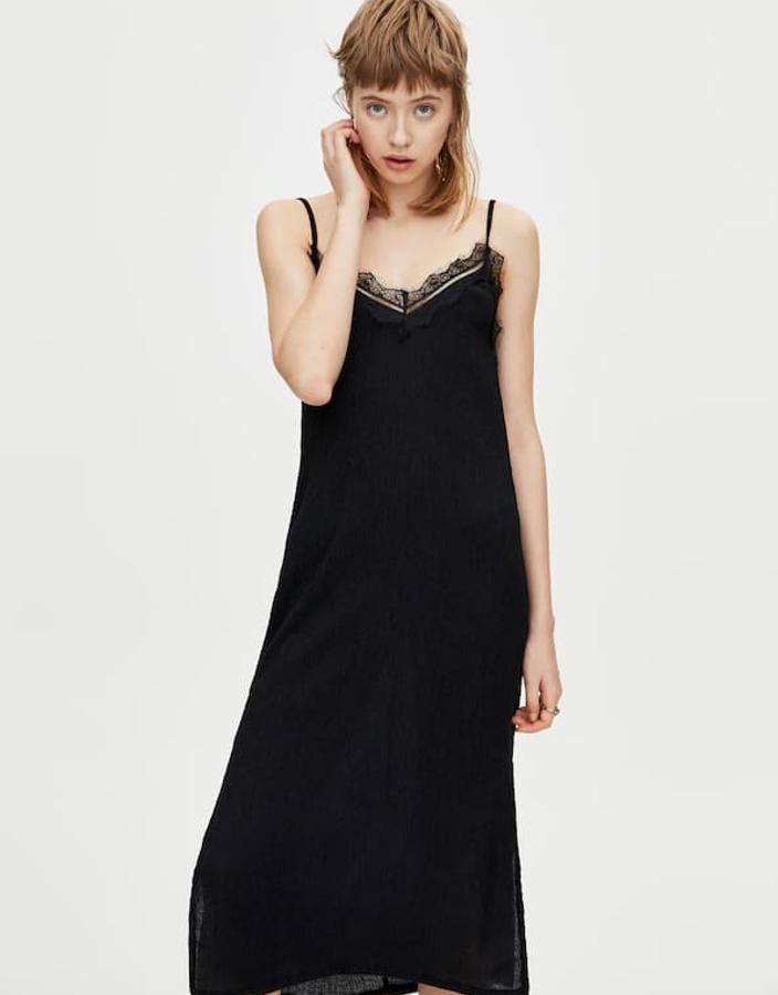 Vestido midi estilo lencero con tirantes ajustables, detalle de encaje en el escote de pico y aberturas laterales ( Pull&Bear , 19,99 euros).