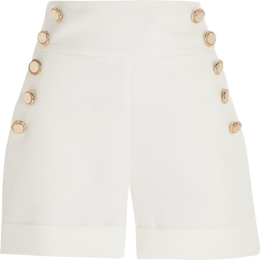 Pantalón corto blanco con detalles de botones dorados y bolsillos laterales. (River Island, 40,00 euros).