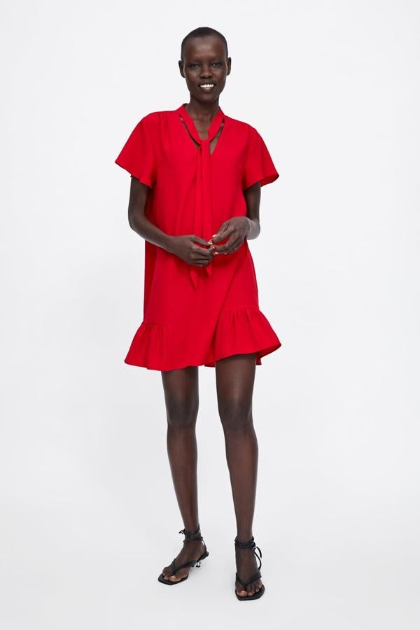 Vestido fluido con escote en pico, detalle de lazo en el cuello y bajo con volante, 25,95 euros.