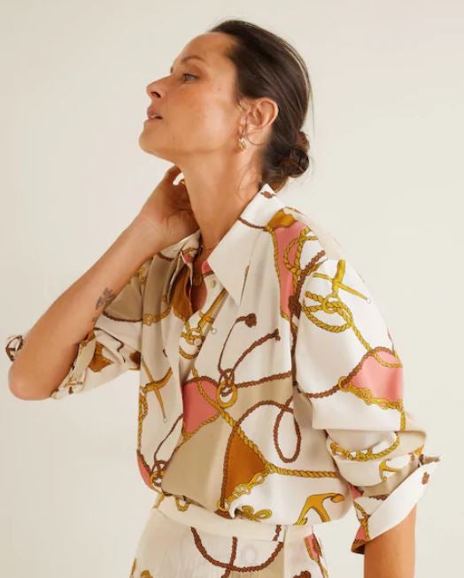 Blusa de Mango con estampado de cadenas en tono blanco, dorado y rosa pastel. (39,99 euros)