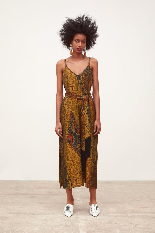 Para un look sofisticado, nos quedamos con este vestido de estilo lencero y estampado étnico con cinturón a juego rematado en flecos. Cuesta 39.95 euros en Zara.