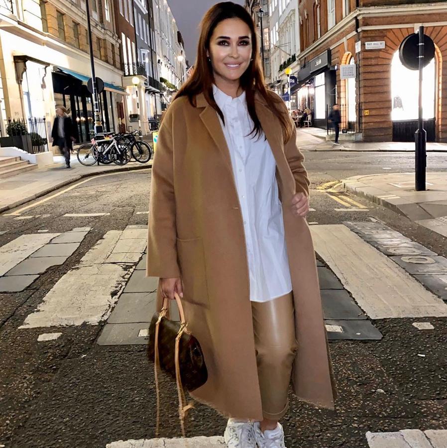 Si no tienes un abrigo camel en tu fondo de armario de invierno, está incompleto. Ella apostó por uno de Zara, que combina con camisa blanca y unos pantalones del mismo tono de efecto piel. ¡El look perfecto para viajar!