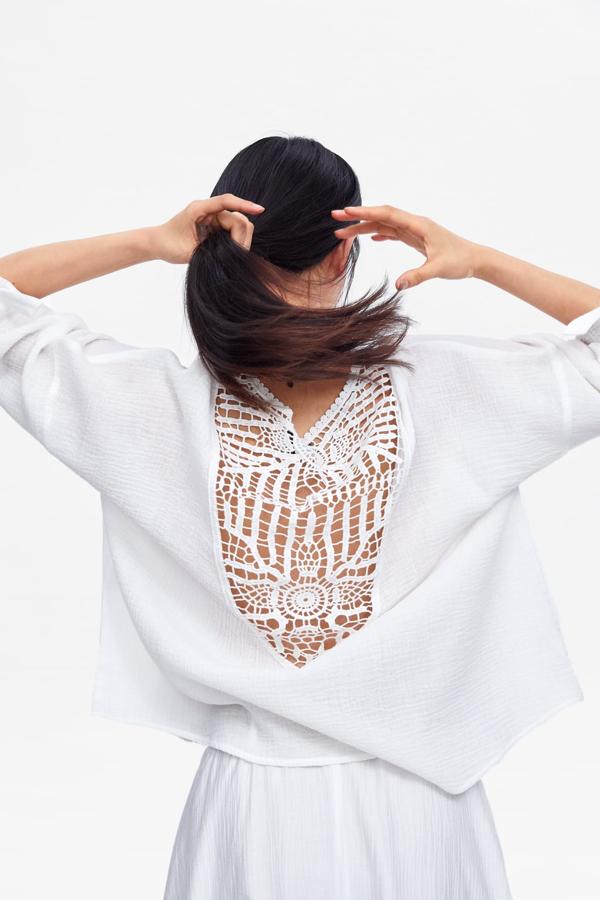 Blusa con tejido combinado en color blanco roto y con mangas largas acabadas en puño con lazada, 25,95 euros.