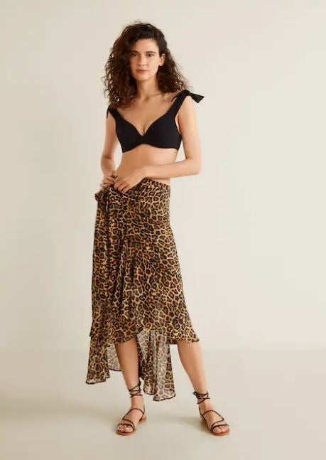 Una de las versiones más sexis es esta falda pareo de leopardo con la que podrás ir a la piscina, pero también salir de fiesta con tus amigas si la combinas con un body negro y unos taconazos de infarto. De Mango (29,99 euros).